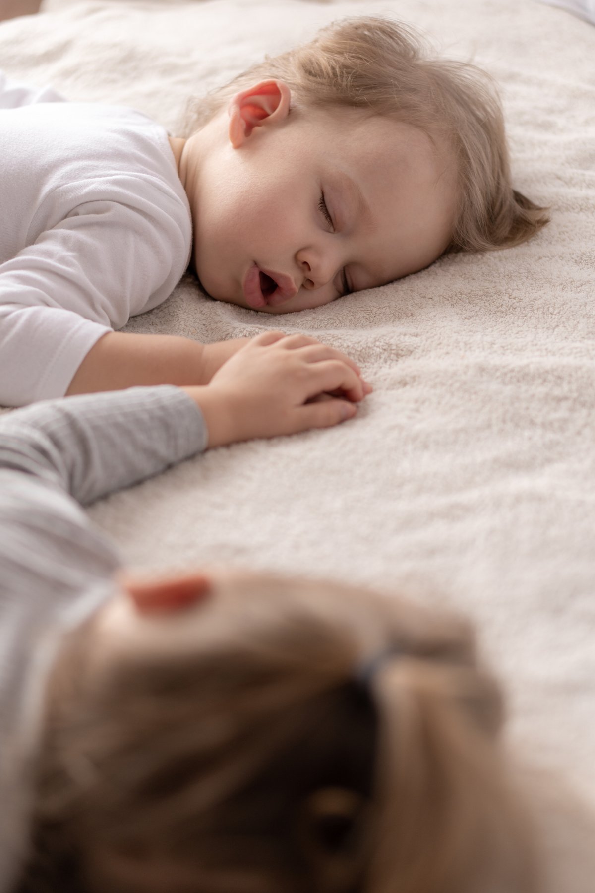 Close Up of Siblings Holding Hands while Sleeping